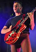 Jack Antonoff tampil, memegang sebuah gitar elektrik merah