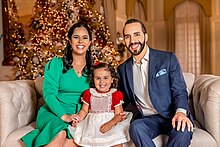 Formal photo of a smiling Bukele, his wife, and their older daughter