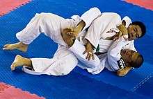 A grappler applies a lock to his opponent's neck