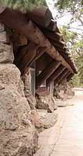 alt=Exterior photograph of the Fishing Bridge Museum, showing the rustic log construction.