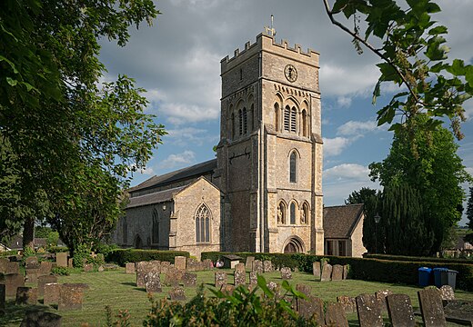 St. Peter's Church, Brackley, in 2023. View from a northwestern direction in afternoon light, with the curchyard in the foreground.