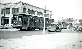 Two streetcars passing on a wide street