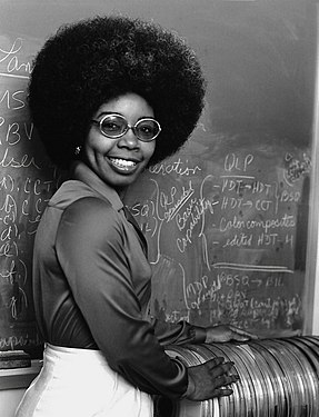 Valerie Thomas next to a stack of the Landsat Computer Compatible Tapes she worked out the image formats for. Photograph by NASA, restored by Adam Cuerden