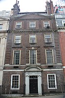 A brownish brick townhouse with stone trim