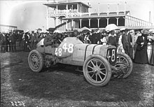 Photo d'ensemble de Henri Cissac prenant la pose au volant.