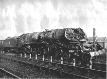 Beschädigte Dampflokomotive mit eingedrückter Rauchkammer im vorderen Kesselbereich sowie fehlenden Dampfzylindern und Treibstangen