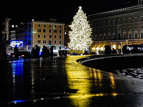 Riflessi di luci natalizie sulla fontana a Piazza Venezia, Roma