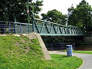 Iron bridge over the River Aire linking the mills and houses of Saltaire with Roberts Park