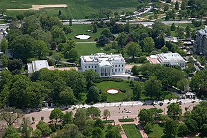 Vita huset norrifrån, med huvudbyggnaden i mitten och östra flygeln till vänster och den västra flygeln till höger. Pennsylvania Avenue är här en gågata.