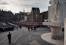 Koning en koningin leggen in 2014 de eerste krans bij het Nationaal Monument op de Dam in Amsterdam.