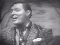 Bill Haley of Bill Haley & His Comets singing "Rock Around the Clock", 1955