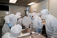 An investigator flashes V-for-victory signs upon the 2006 arrival of material gathered by the Stardust spacecraft at the Johnson Space Center in Texas.