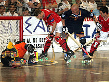 Un joueur de rink hockey avec la balle dans sa crosse à l'approche du but