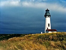 Phare de « Yaquina Head » (Oregon) ; la petite maison blanche adossée à un phare trapu ressemblent à là où commence.