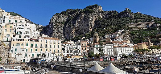 Harbour of Amalfi and Torre dello Ziro on mountain.