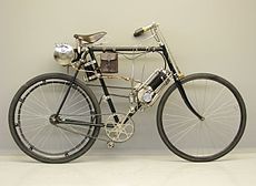 Clément 1¼ pk (125 cc) 1902 met bobine-ontsteking. De bobine zit onder het zadel, de loodaccu in het tasje aan de framebuis.