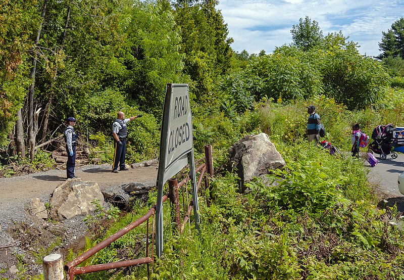 File:RCMP telling asylum seekers attempting to cross border that they must enter Canada somewhere else since this is not an official entry point.jpg