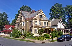 Three houses, pink, brown and gray, on one corner of Regent and Caroline streets