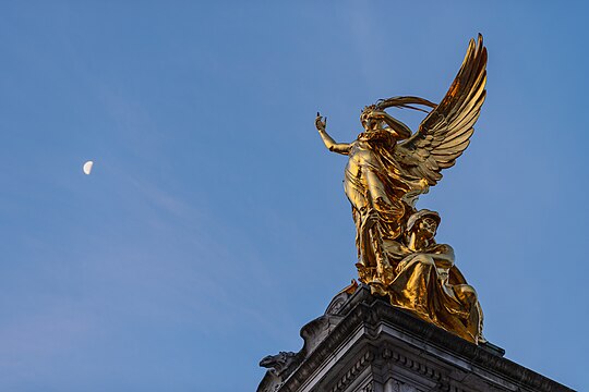 Victoria Memorial with Nike Statue in London in early morning, with moon in the background, 2020.