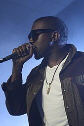 Kanye West đang đeo kính và trình diễn