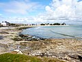 La plage de Langoz vue de la pointe de Kergall ; à l'arrière-plan le phare de la pointe de Langoz.