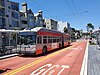 A bus stop with a trolleybus in the median of an urban arterial