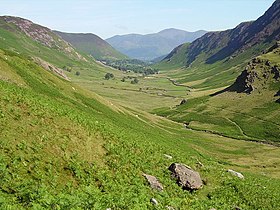 Outdoor countryside scene, with fells on either side of lush green valley