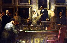 colour a paining of men and women in formal Edwardian dress, standing around (and one woman seated at) a boardroom table