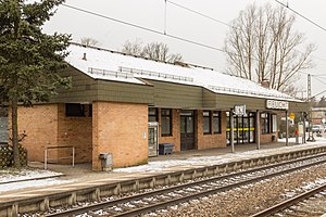 One-story brick building with slanted roof covered in snow