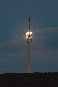 The Fernsehturm Stuttgart (TV Tower Stuttgart) with the full moon rising behind it.