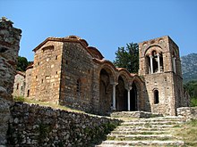 photographie couleurs : une église et son clocher sur la droite en haut de marches