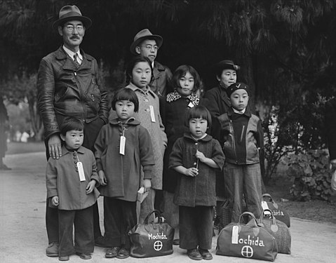 Hayward, California. "Members of the Mochida family awaiting evacuation bus. Identification tags are used to aid in keeping the family unit intact during all phases of evacuation. Mochida operated a nursery and five greenhouses on a two-acre site in Eden Township. He raised snapdragons and sweet peas." (created by Dorothea Lange, restored & nominated by Bammesk)