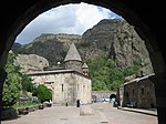 View at a church with cliffs in the background through an arch