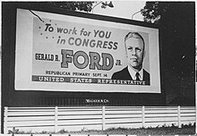 A Billboard shows a portrait of a man in a suit, with the text "To work for You in congress" at the top, followed by "Gerald R. Ford Jr.", followed by "Republican Primary September 14", with "United States Representative" across the bottom of the sign.