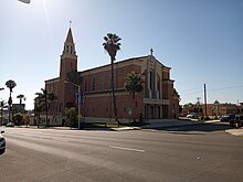 Blessed Sacrament Catholic Church: College Area Business District signs hang from the streetlight in front.