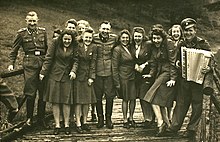 Men and women in uniform smiling and posing with musical instruments