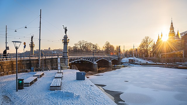 Djurgårdsbron in the morning, towards the island Djurgården, Stockholm. The sun is rising above Nordiska museet.