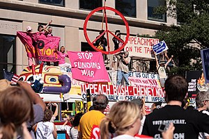 A bus festooned with peace signs, symbols and demonstrators