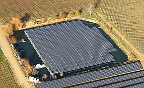 Photographie aérienne d'un plan d'eau sur lequel des panneaux solaires ont été installés.