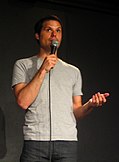 Michael Ian Black holding a microphone at a stand-up comedy performance