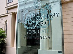 a classical building with a modern sign identifying it as the Royal Academy of Music