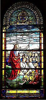 Christ standing on mountain, stretches his arm towards the people gathered to hear Him speak.