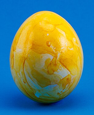 Yellow colored easter egg on a blue background