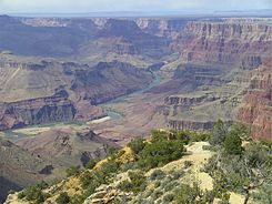 Black basalt cliff of Tanner Graben-(left edge, photo, down-dropped, north side of Colorado River, with multi-banded, horizontal Nankoweap Formation on top), site of Tanner Canyon, opposite, and Tanner Rapid at cliff base)