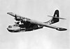 Black-painted twin-engined high-wing military aircraft in flight