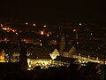 Marktplatz mit hell erleuchtetem Stadthaus, dahinter das Rathaus