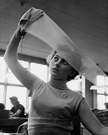 A woman stretching a sheer stocking with her hands to inspect it