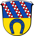 Wappen der Gemeinde Messel, in deren oberer Hälfte mit der ebenfalls blauähnlichen Schildfarbe und dreifacher geschachtetem Schrägrechtsbalken auf die früheren Herren von Groschlag Bezug genommen wird.