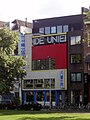 Oud, Cafè De Unie (1925), Rotterdam, ch'a mostra d'element ëd contaminassion modernista con soa ansëgna tridimensional.