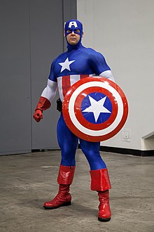 Captain America tient son bouclier de même couleur que son habillement : étoile,bleu, rouge, blanc